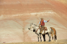 USA, Wyoming, Cowboy With Two Horses In Badlands