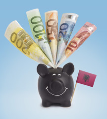 Various european banknotes in a happy piggybank of Albania.(seri