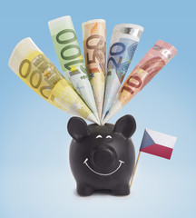 Various european banknotes in a happy piggybank of Czech Republi