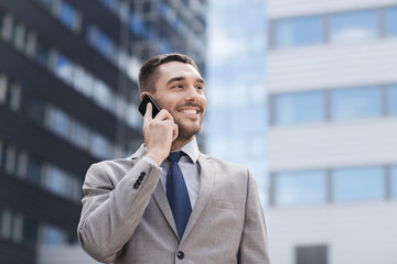 Wall Mural - smiling businessman with smartphone outdoors