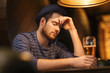© Syda Productions - unhappy lonely man drinking beer at bar or pub
