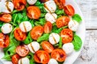 salad of mozzarella, cherry tomatoes and spinach with balsamic sauce closeup