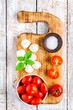 mozzarella, cherry tomatoes, sea salt, basil on old cutting board
