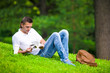© travnikovstudio - Young man relaxing with coffee in park reading a book