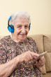 lovely senior woman listening music from smart phone with headphone