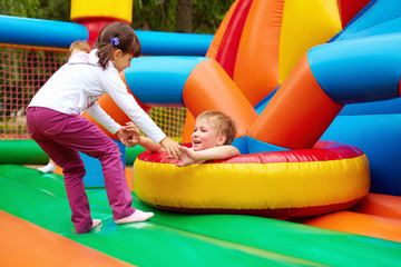 Wall Mural - happy kids having fun on inflatable attraction playground