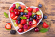 Leinwandbild Motiv Fruit salad in heart shaped bowl - healthy eating