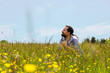 Attraktiver Mann sitzt in einer bunten Alpenwiese