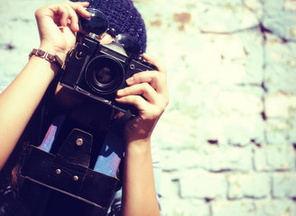 Retro photographer. Modern urban girl has fun with vintage photo