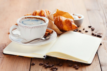 Wall Mural - Fresh croissants and cup of coffee on a table