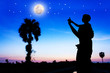 © napatcha - Silhouette of father use hand point his son look at the full moon on the sky after sunset