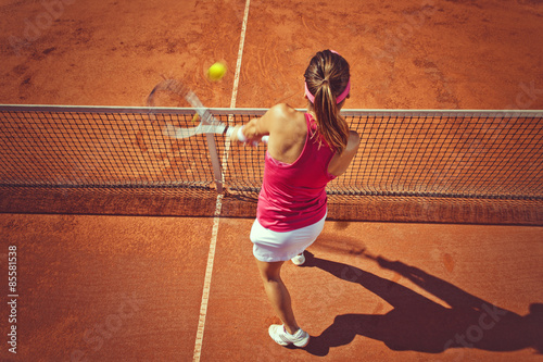 Young woman playing tennis.High angle view.Backhand volley. Poster