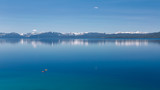 Fototapeta Na sufit - Photograph of two kayaks on calm Lake Tahoe with view on snowy peaks of Sierra Nevada mountains