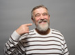© kostyha - portrait of an elderly man with a beard finger near head