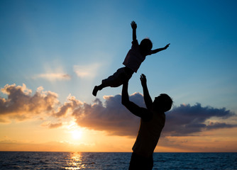 Wall Mural - Silhouettes at sunset beach