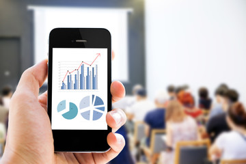 Poster - Close-up hand holding mobile phone with analyzing graph