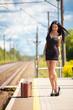 young woman is waiting for a train on the train station