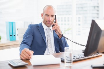 Businessman on the phone and writing notes