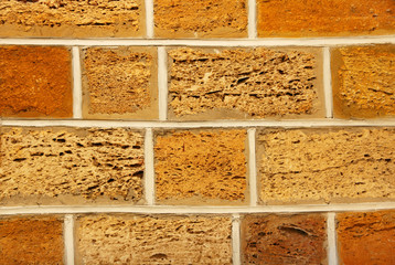 Yellow and orange shell limestone brick wall as abstract backgro