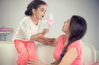 © spass - Young mother and little cute daughter playing with pinwheel