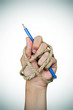 hand tied with rope holding a pencil