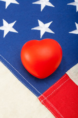 Wall Mural - Toy heart over US flag - close up studio shot