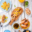 Grilled Seafood Dishes on White Wooden Table