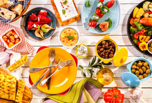 Colorful Mediterranean Meal On White Picnic Table