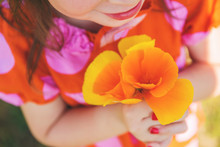 Close-up Of A Girl Holding Orange Flowers