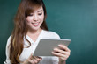 © zhu difeng - asian beautiful woman holding tablet in front of blackboard