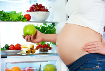 Wall Mural - nutrition and diet during pregnancy. Pregnant woman with fruits