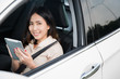 © torwaiphoto - A woman using a tablet in the car