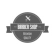 Vintage barbershop logo in gray color. In it hairdressing scissors wrapped in a ribbon.