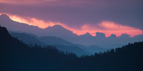 Wall Mural - panoramic himalayan hills and mountains topped with a colorful dramatic sky.