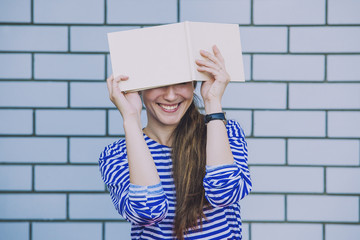 Female model with a white book on the background wall