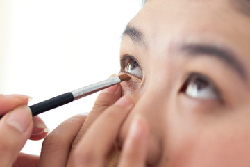 eye makeup with brush on pretty woman face