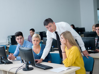 students with teacher  in computer lab classrom