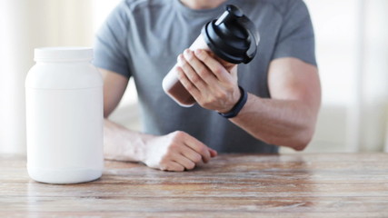 Wall Mural - close up of man with protein shake bottle and jar