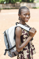 laughing african ethnicity girl proudly holding her sack (bamako, mali)