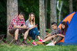 © bokan - Four teenagers camping in nature, spanding time with thier mobile phones
