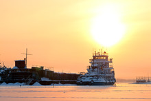 Ship In Frozen River On Background Of Yellow Horizon 