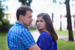 © singulyarra - Young beautiful woman and man in blue stand in summer green park