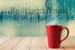 red coffee cup with smoke on water drops glass window background