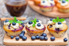 Fresh Muffins With Blueberry And Cup Of Coffee On Wooden Backgro