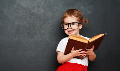 Wall Mural - happy  girl schoolgirl with book from blackboard