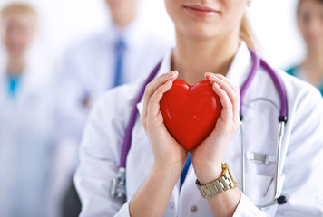 Female doctor with stethoscope holding heart