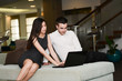 © W PRODUCTION - two business people man and woman working on a computer while waiting in airport lounge