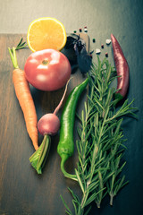 Vegetables and herbs with sea salt on brown cutting board on a b