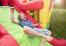 Child On Inflatable Bouncy Castle Slide
