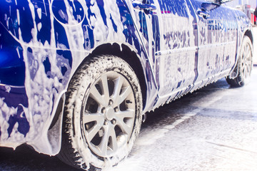 Car wash with flowing water and foam.